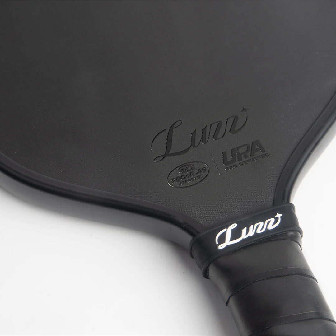Close-up of a Luzz Pro Cannon black pickleball paddle with 'Luzz' branding, PBCoR .43 certification and UPA-A pro certification on a white background
